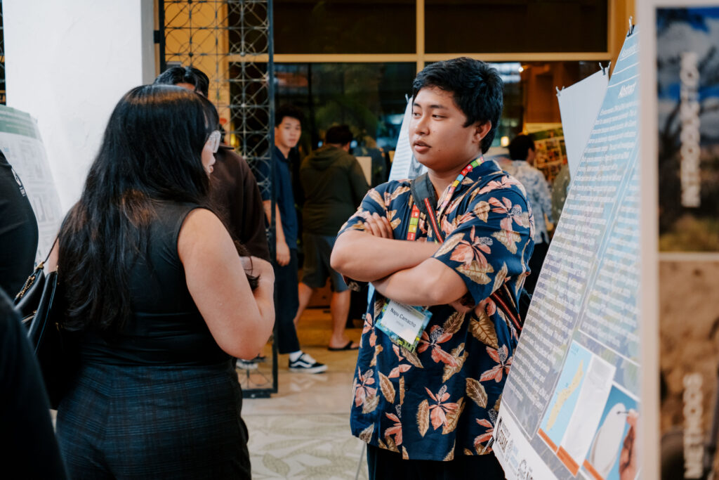 EPSCoR undergraduate student researcher Napu Camacho with his poster at the 2025 Conference on Island Sustainability.