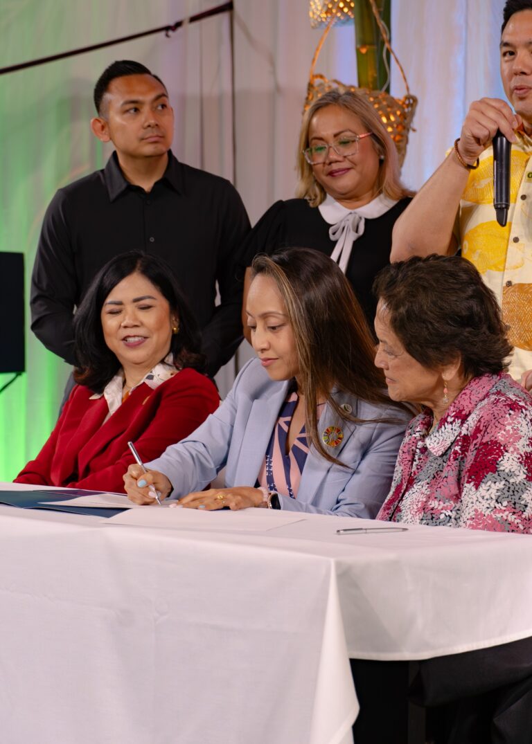 GVB President & CEO Regine Biscoe Lee signs an MOU with the University of Guam's Guam Green Growth organization on Friday as UOG President Anita Borja Enriquez (L) and Governor Lourdes Leon Guerrero (R) look on.