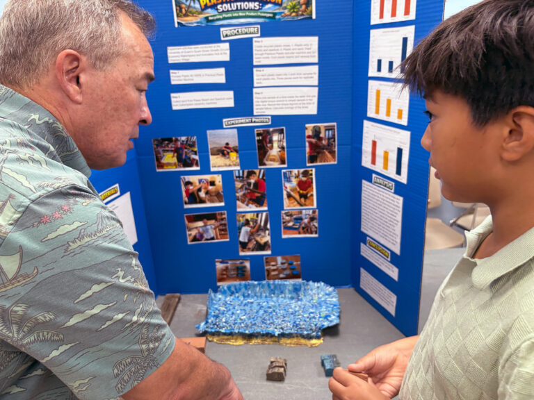 St. John’s student Anthony Shelton presents his first place division winning project to Congressman James Moylan during the Island Wide Science Fair.  Shelton tested the strength of various additives into the making of plastic lumber from recycled plastics.  He said he wanted to help address the thousands of pounds of plastic waste that ends up in the landfill on Guam with his experiment. 