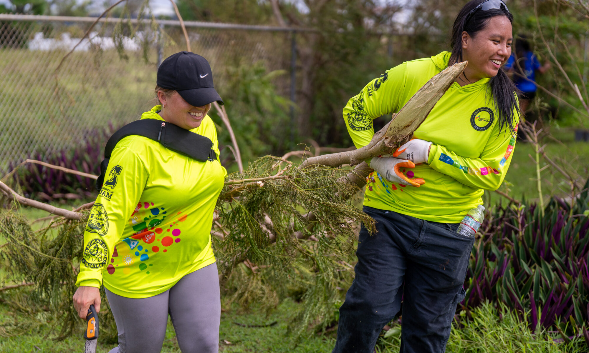 Members of the Guam Green Growth Conservation Corps carrying a tree branch.