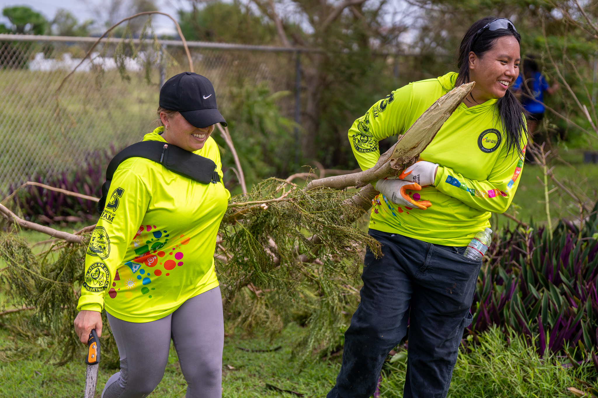 Members of the Guam Green Growth Conservation Corps carrying a tree branch.