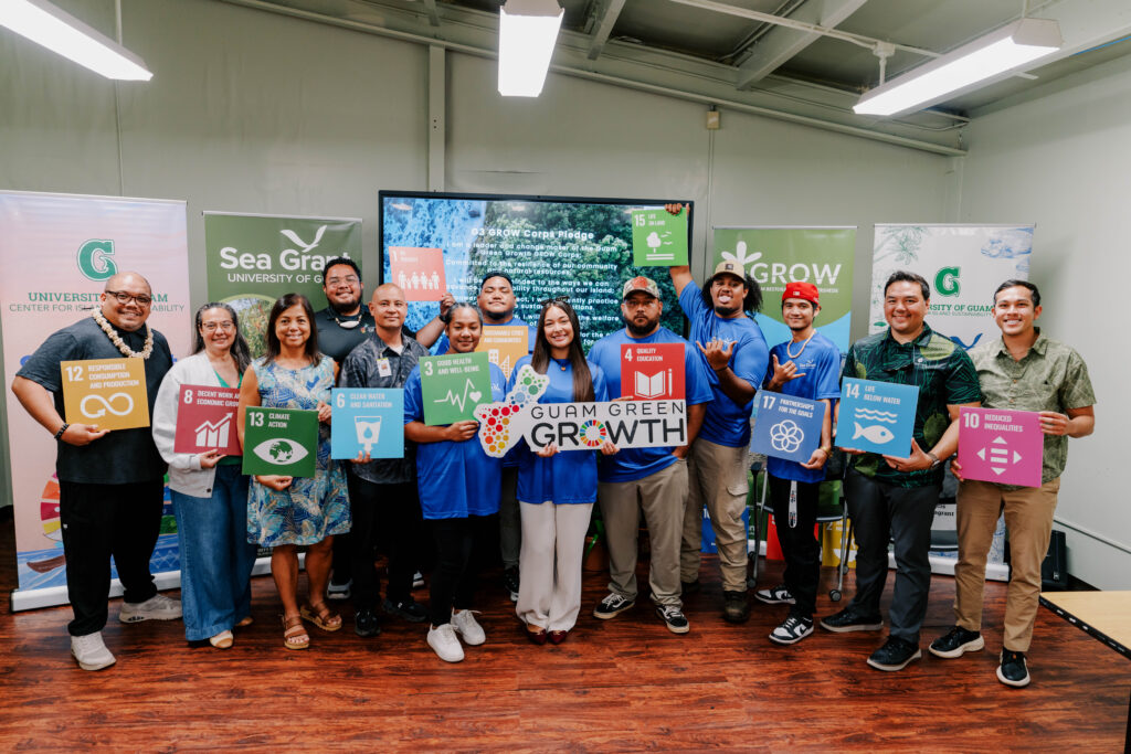 The second G3 GROW Corps cohort and UOG CIS & Sea Grant leadership pose holding colourful Sustainable Development Goal signs and a Guam Green Growth plaque.